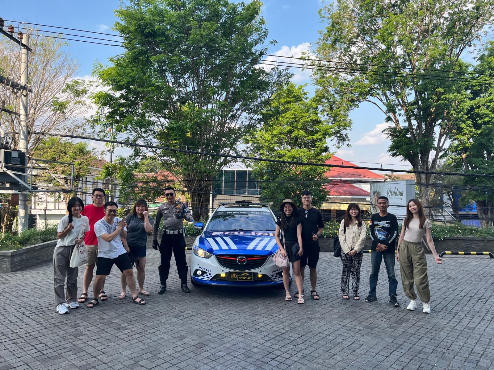 JVTO group standing with a traffic police officer and patrol car outside the hotel in daylight after an escorted drive